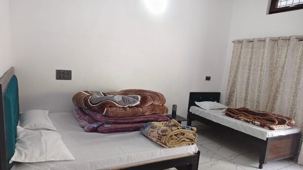 Un dormitorio con dos camas, una ventana con cortinas y suelo de baldosas.