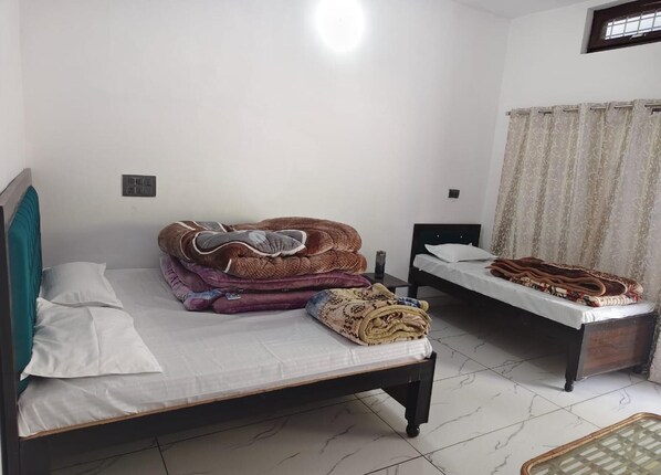 A bedroom with two beds, a window with curtains, and a tiled floor. - Shaaneshwar Mahadev Hotel & Restaurant (Ukhimath)