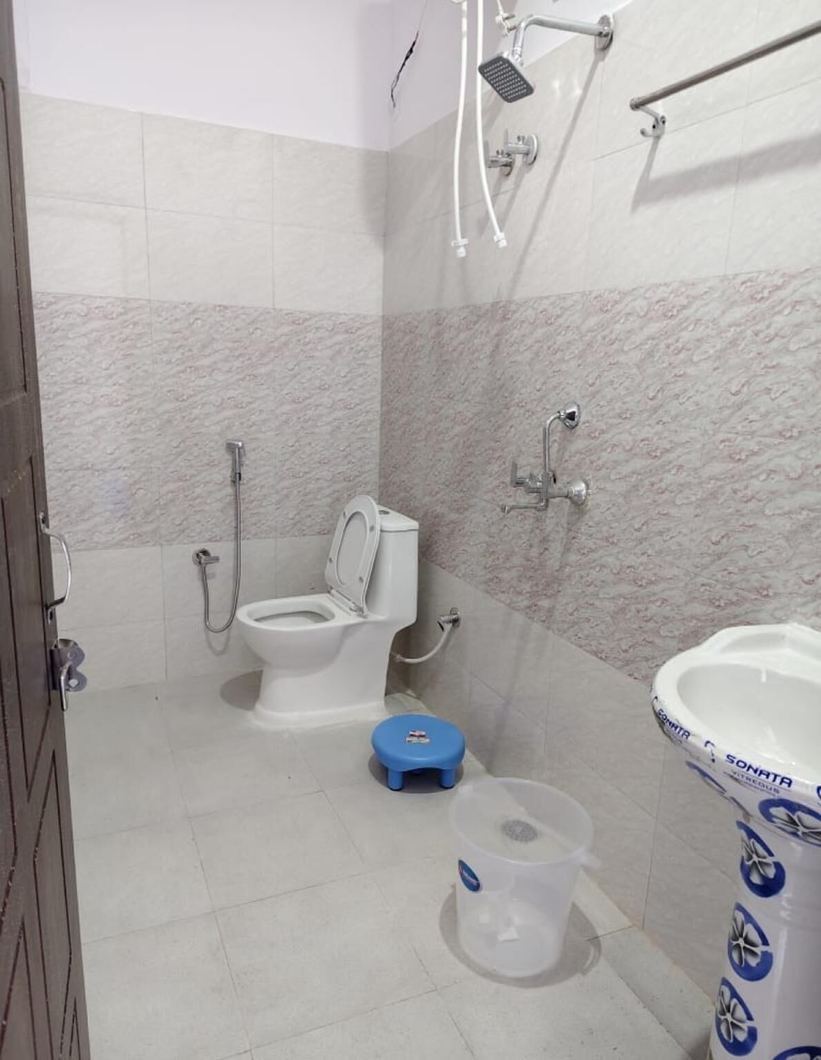 A bathroom with a toilet, bidet, shower, and sink.