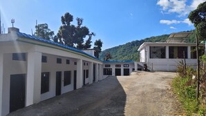 Un edificio con varias habitaciones y un sendero de tierra que conduce a él.