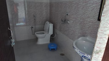 Une salle de bain équipée de toilettes, d’un bidet et d’un lavabo.