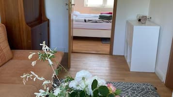A bedroom with a bed, a bedside table, a wardrobe, and a view of the outside.