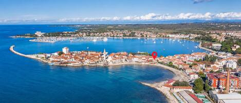 Un pueblo costero con un puerto deportivo, edificios a lo largo del muelle y un cielo azul despejado.