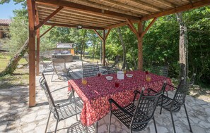 An outdoor patio with a table covered in a red floral tablecloth, surrounded by metal chairs. - Amazing home in Rovinj with WiFi (Rovinj)