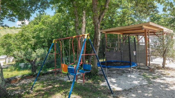 A playground with swings and a trampoline, surrounded by trees and a covered seating area. - Amazing home in Rovinj with WiFi (Rovinj)