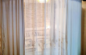 A room with a view through sheer curtains, a chandelier, and a patterned wall. - Awesome apartment in Dramalj with WiFi (Dramalj)