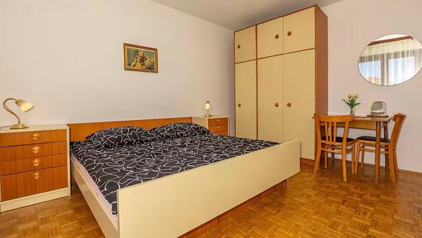 A bedroom with a bed, a desk, a chair, a wardrobe, and a mirror. - Beautiful apartment in Crikvenica with WiFi (Crikvenica)