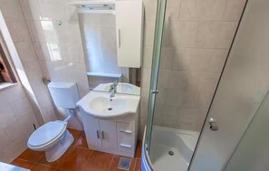 Ein Badezimmer mit Toilette, Waschbecken und einer Duschkabine.