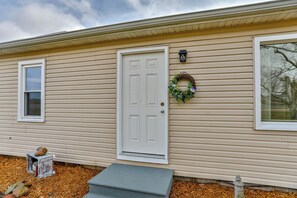 A single-story house with a white front door, a small window, and a wreath decoration. - Country Corner Inn - 3BR Stay for Professionals (Wausau)