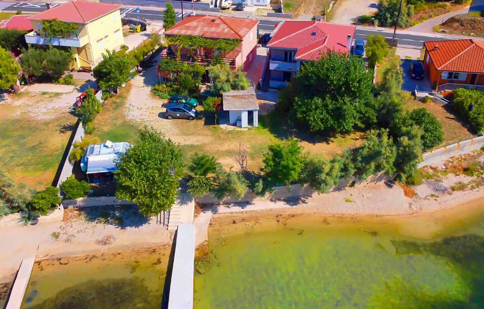 Vue aérienne d’un quartier résidentiel avec des maisons, un petit plan d’eau et une route.