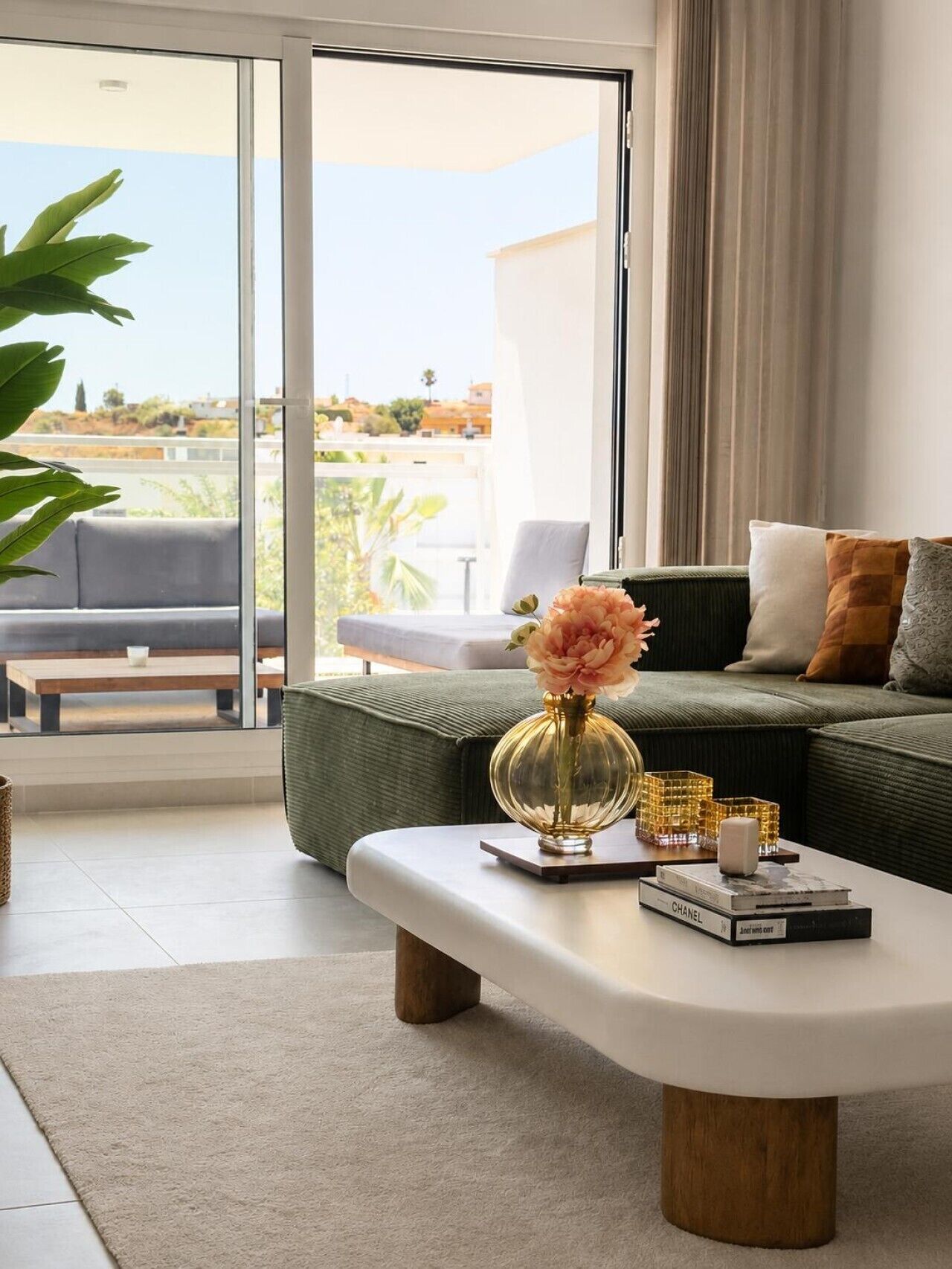 Ein modernes Wohnzimmer mit einer Couch, einem Couchtisch und Blick durch eine Glastür.