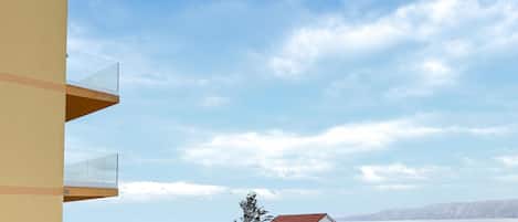 Un área residencial con casas, cielo despejado y una masa de agua al fondo.