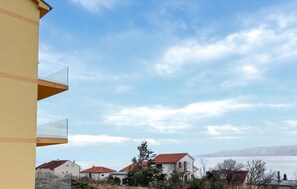 A residential area with houses, a clear sky, and a body of water in the background. - Amazing apartment in Novi Vinodolski with WiFi (Novi Vinodolski)