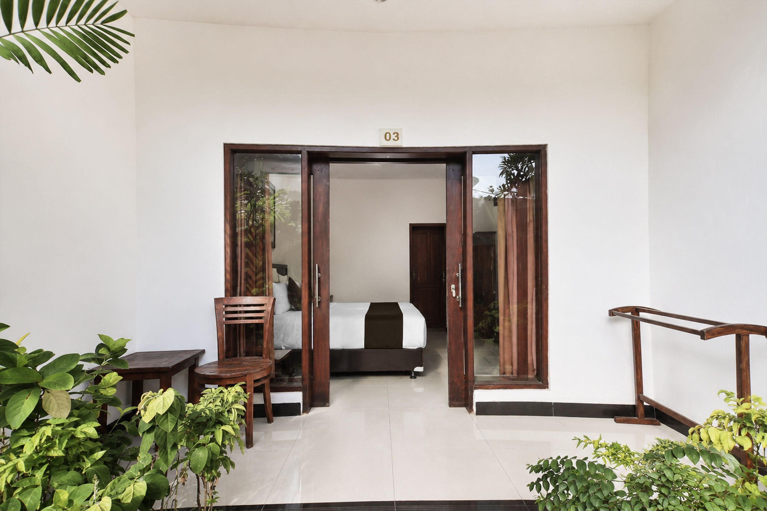 Una habitación de hotel con una cama, una silla, una mesa y una puerta que da a la habitación.