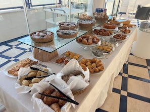 A buffet table with various baked goods and pastries.