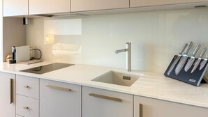A modern kitchen with a white countertop, a sink, and a knife block. - Cozy apartment in Palit with WiFi (Palit)