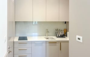 A modern kitchen with white cabinets, a stainless steel faucet, and a knife block. - Gorgeous apartment in Palit (Palit)