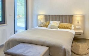 A bedroom with a bed, bedside lamps, a window, and a view of greenery outside. - Lovely apartment in Palit with WiFi (Palit)
