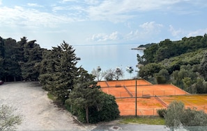 A tennis court with a view of a lake and surrounding trees. - Nice apartment in Rab with WiFi (Rab)