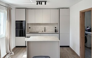 A modern kitchen with a central island, built-in appliances, and a view to the adjacent room. - Stunning home in Opatija-Moscenicka (Opatija-Moscenicka)