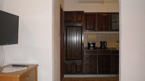 A compact kitchen with wooden cabinets, a microwave, and a coffee maker. - Lovely apartment in Sveti Juraj with WiFi (Sveti Juraj)