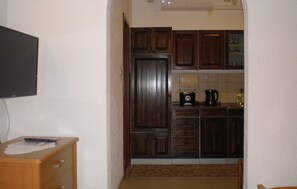A compact kitchen with wooden cabinets, a microwave, and a coffee maker. - Lovely apartment in Sveti Juraj with WiFi (Sveti Juraj)