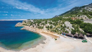 A coastal area with a beach, rocky terrain, and a few buildings. - Gorgeous apartment in Karlobag with WiFi (Karlobag)