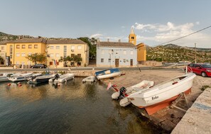 Ein Hafen mit vertäuten Booten, einer Kirche und Wohnhäusern.