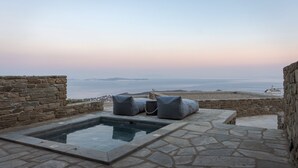 A stone pool with seating and a view of the sea. - Fos Suite by Vivian Horizon Tinos, Vivian Suites Tinos (Tinos)