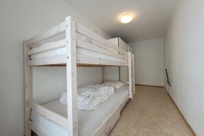 A bunk bed with a mattress and pillows, a door, and a light fixture on the ceiling. - Apartment on the coast for 6 people (MIDDELKERKE)