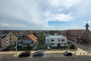 A residential area with a mix of modern and traditional architecture, including a church with a prominent steeple. - Apartment on the coast for 6 people (MIDDELKERKE)