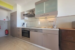 A modern kitchen with stainless steel appliances, a built-in oven, and a dishwasher. - Apartment with Panoramic Sea Views (MIDDELKERKE)