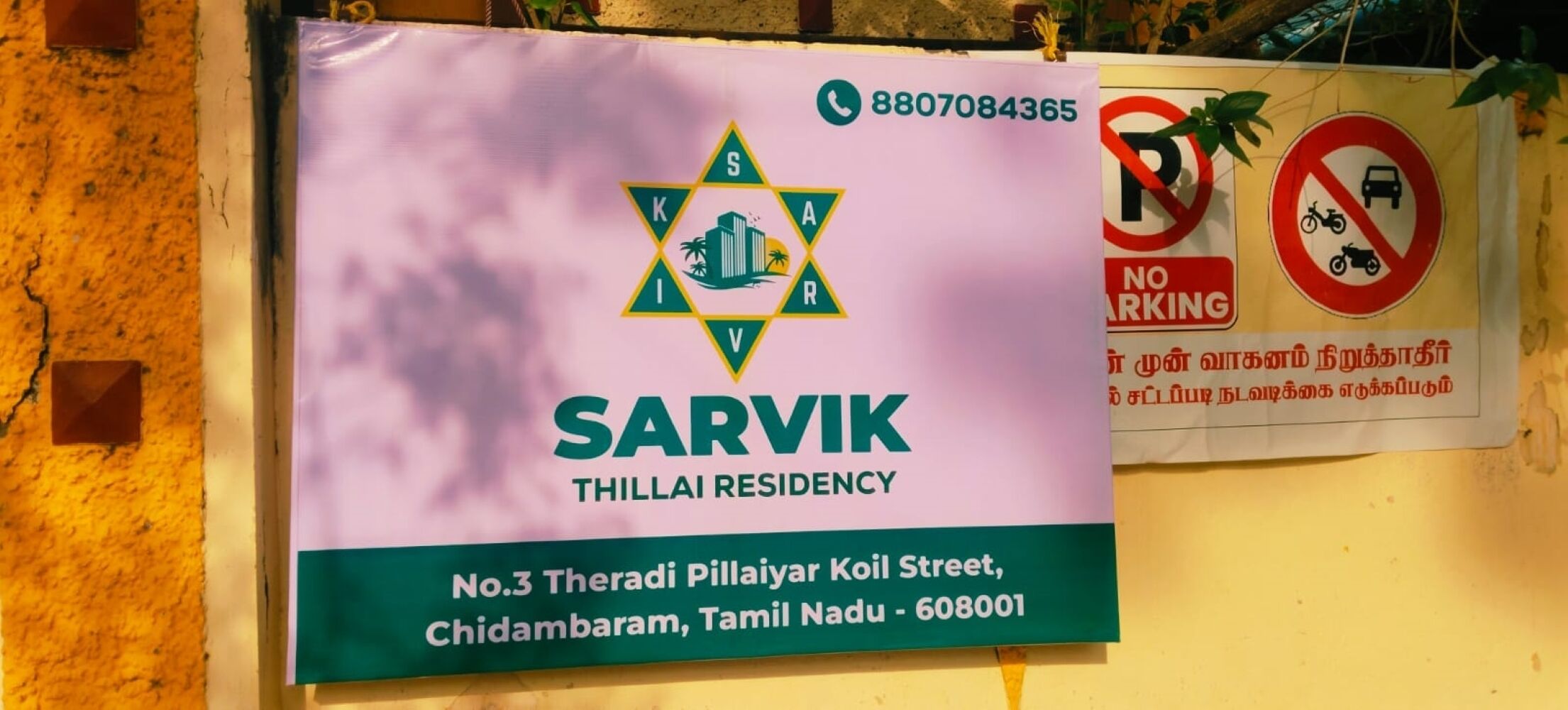 A sign for Sarvik Thillai Residency with contact information and address.