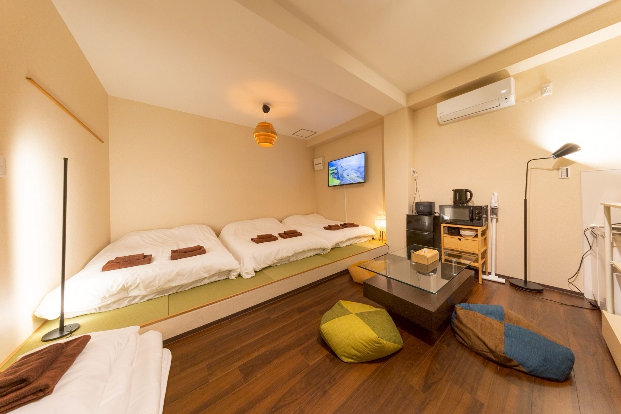 A modern hotel room with a bed, a TV, a coffee machine, and a desk.