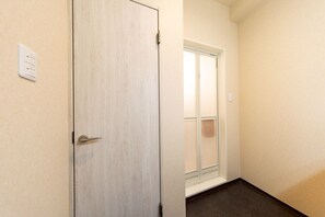 Um corredor com uma porta de madeira e uma janela com vista.