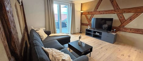 A modern living room with a sofa, a coffee table, and a TV stand.