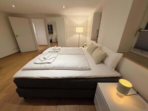 A modern bedroom with a large bed, bedside lamps, and a nightstand. - Neumuehle - Historisch und modern - Wohnung 4 (Altenkunstadt)
