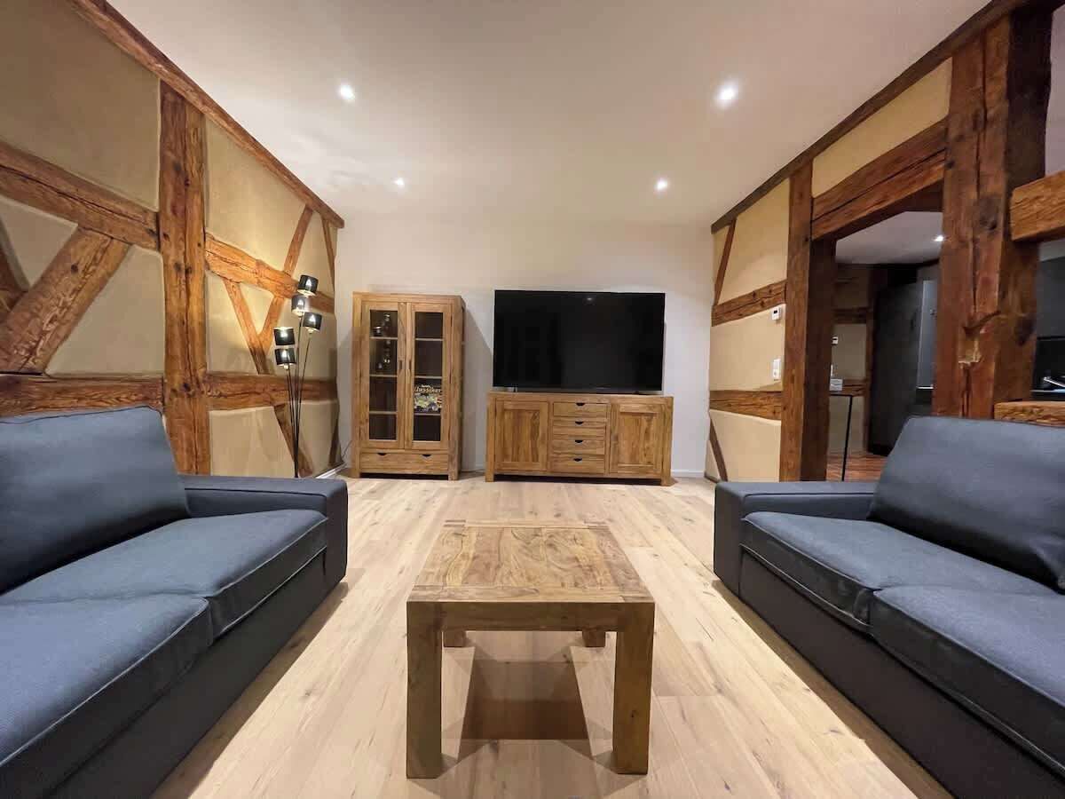 En stue med to sofaer, et træbord og et fjernsyn.