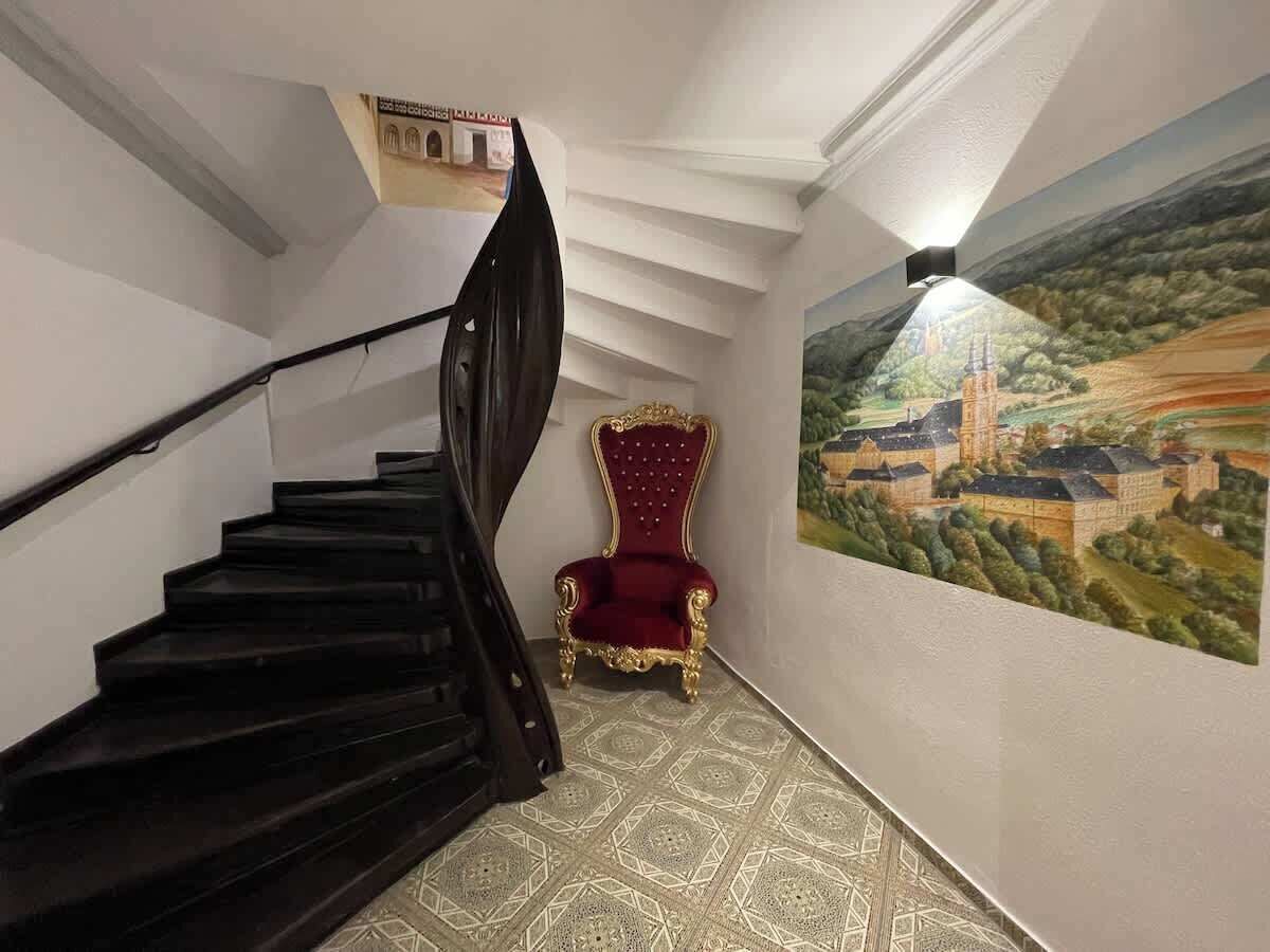 Eine Treppe mit einem roten Stuhl und einem Wandgemälde.
