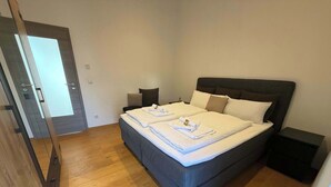 Ein Schlafzimmer mit einem großen Bett, zwei Nachttischen und Holzboden.