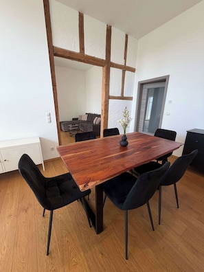 A dining area with a wooden table, black chairs, and a modern interior design.