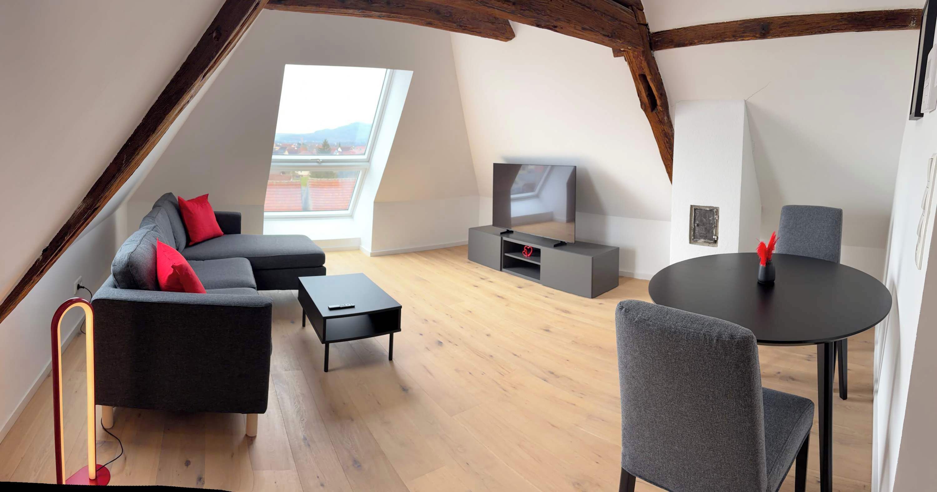 Un espace de vie moderne de style loft, comprenant un canapé, un téléviseur et un coin repas.