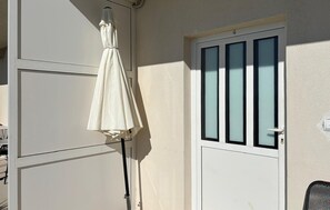 A white door with a window, a white wall, and a white umbrella. - Gorgeous apartment in Podgora with WiFi (Podgora)