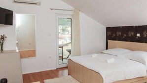 A bedroom with a bed, a TV, a window, and a door leading to an outdoor area. - Stunning apartment in Podstrana with WiFi (Podstrana)