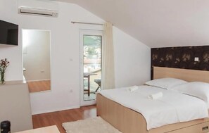 A bedroom with a bed, a TV, a window, and a door leading to an outdoor area. - Stunning apartment in Podstrana with WiFi (Podstrana)