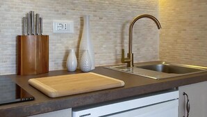 A kitchen with a modern design, featuring a sink, a cutting board, and a knife holder. - Stunning apartment in Podgora with WiFi (Podgora)