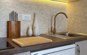 A kitchen with a modern design, featuring a sink, a cutting board, and a knife holder. - Stunning apartment in Podgora with WiFi (Podgora)