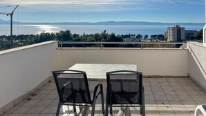 A balcony with a table and chairs, overlooking a body of water and distant mountains. - Stunning apartment in Tucepi with house sea view (Tucepi)