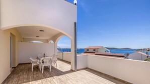 A balcony with a table and chairs, a clear view of the sea, and a building with a red roof in the background. - Cozy home in Trogir with private swimming pool, can be inside or outside (Trogir)