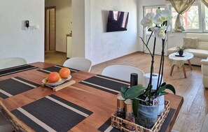 A dining area with a wooden table, a bowl of fruit, and a potted plant. - Cozy home in Trogir with private swimming pool, can be inside or outside (Trogir)